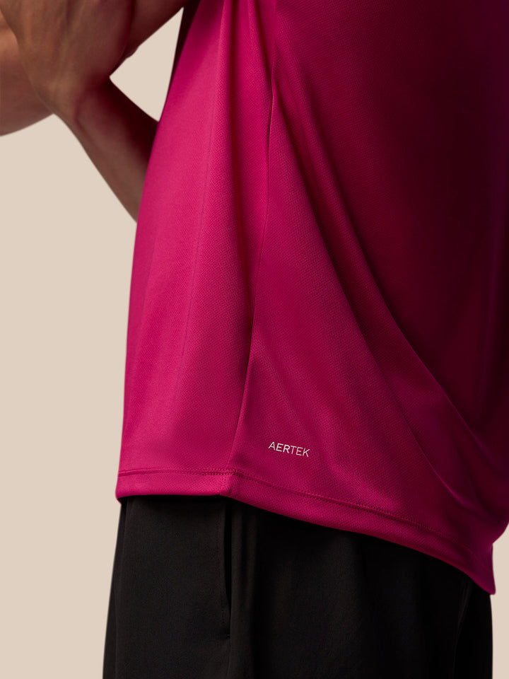 Close up of bright pink Adapt Training T Shirt fabric showing AerTek branding near the hem