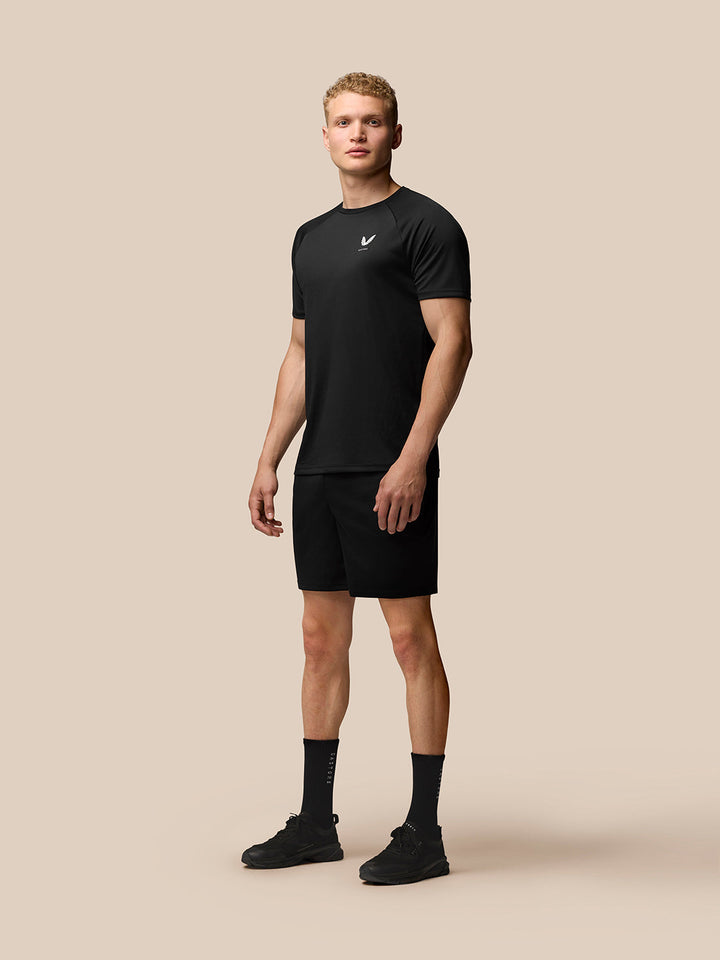 Male model wearing black Adapt Training T-Shirt with crew neck and raglan sleeves; Castore logo on left chest.