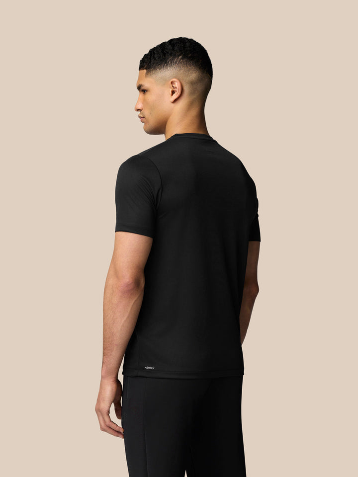 Side view of male model wearing black short sleeve training T shirt with Aertek branding at back hem