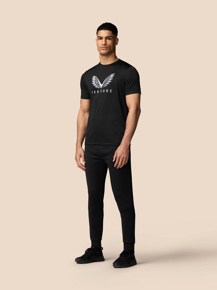 Front view of male model wearing black graphic training T shirt with Castore wings logo on chest