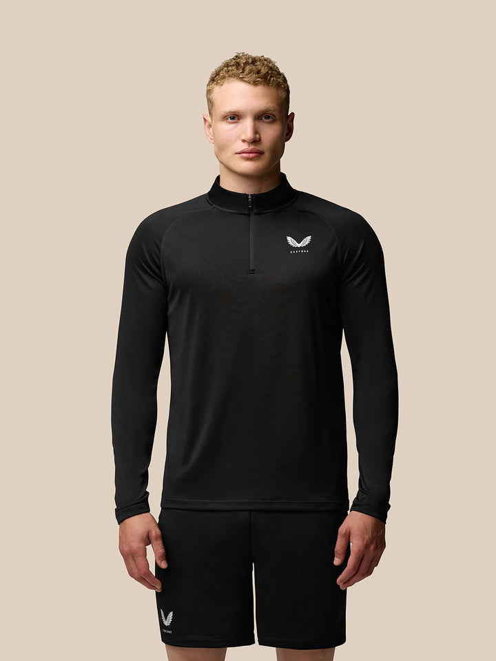 Male model wearing black Adapt Training 1/4 Zip Top with stand collar, raglan sleeves, and front zipper; left chest logo.