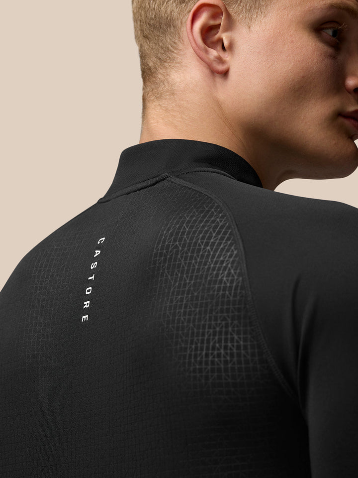 Side view of black Adapt Print Quarter Zip Top with front quarter zip and allover geometric pattern and Castore branding on the left chest