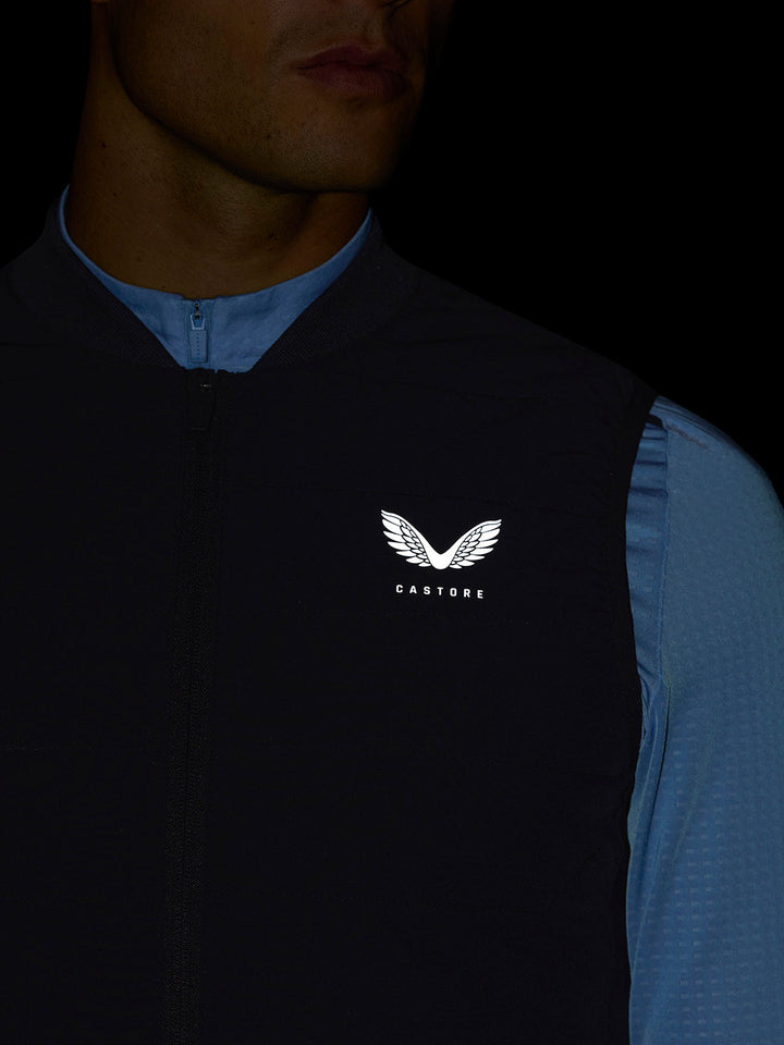 Close up of navy Apex Training Gilet on a model showing the chest Castore logo and center zipper