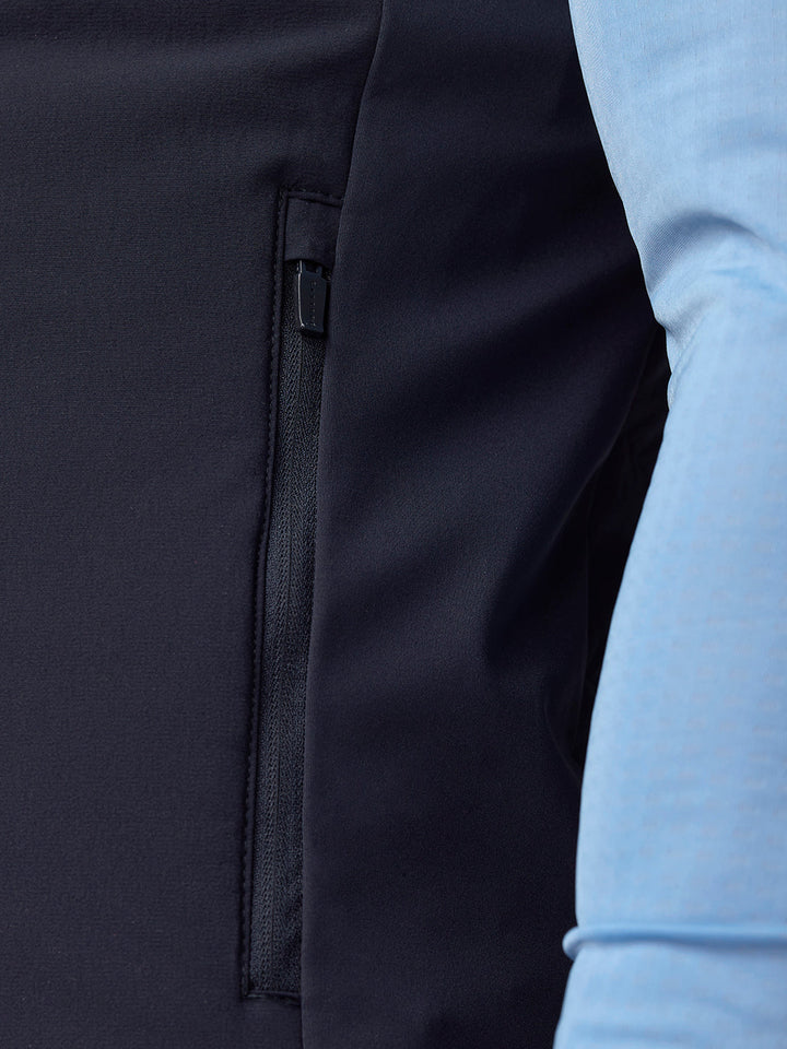 Close-up of a navy Apex gilet side pocket zipper on dark fabric