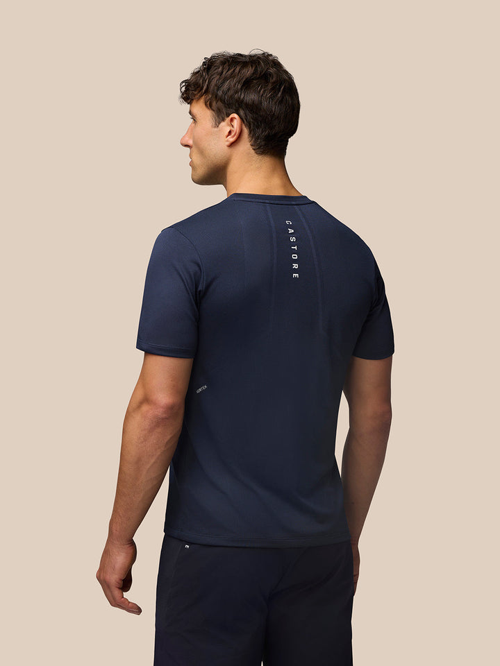 Back view of a man wearing navy Apex Training T Shirt with reflective branding along the upper back.