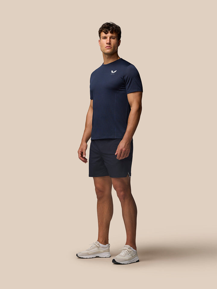 Male model wearing midnight navy Apex Training T Shirt with matching shorts and white sneakers