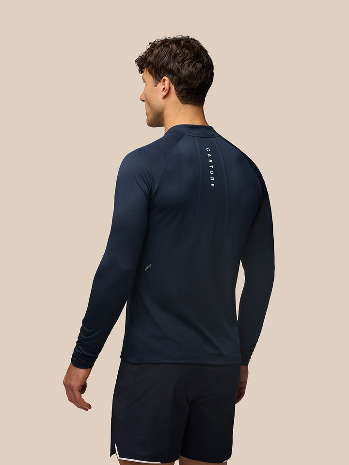 Back view of Midnight Navy Apex Training Quarter Zip Top on a male model with vertical Castore branding along the spine