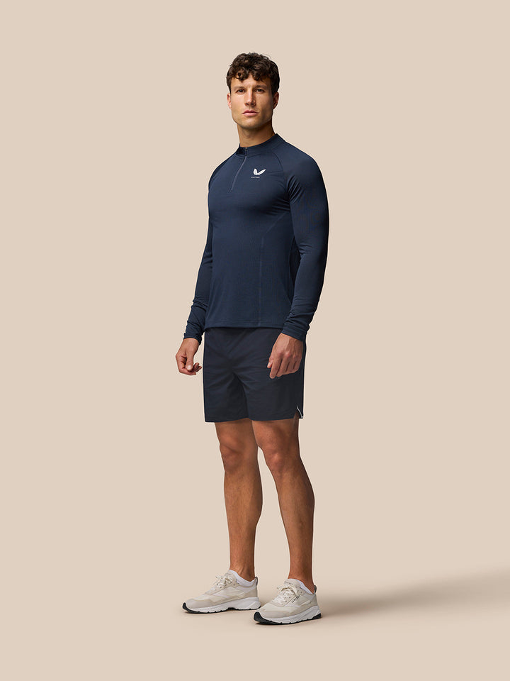 Male model wearing navy Apex Training Quarter Zip Top with stand collar and front zip