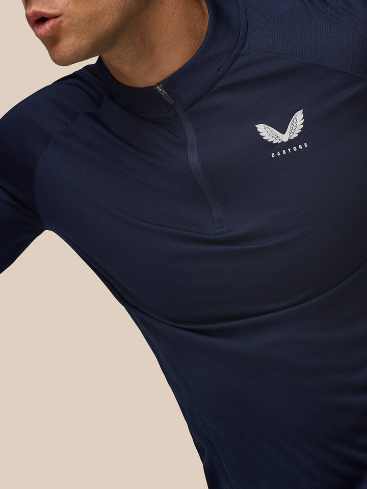 Close-up of navy Apex Training Quarter Zip Top with stand collar and left chest Castore logo