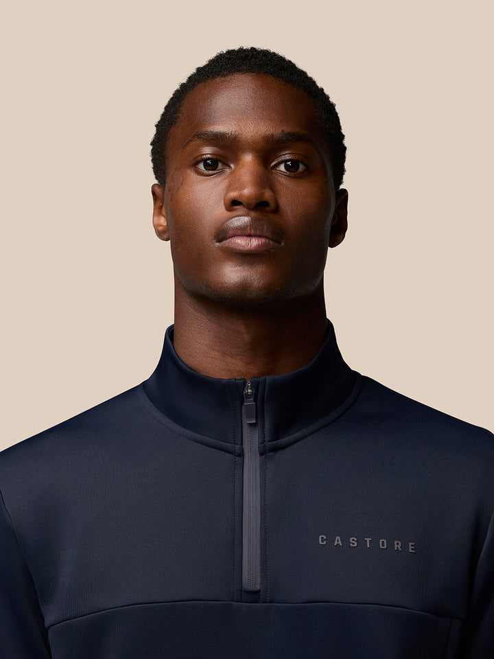 Close up of navy Castore Flex Lifestyle Quarter Zip with front zipper and left chest branding