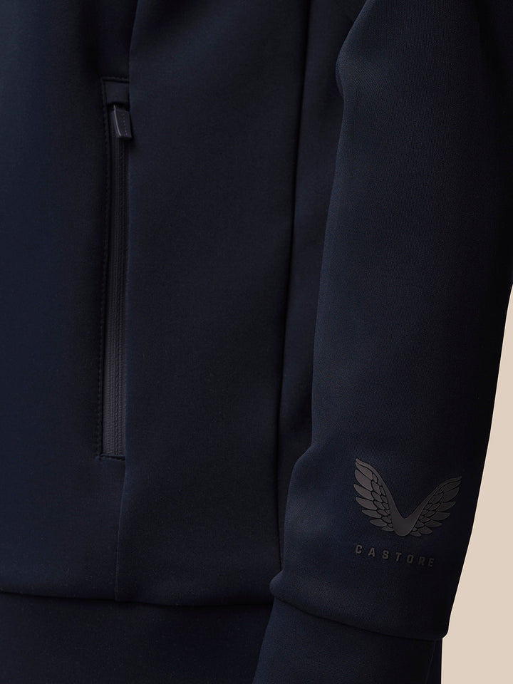 Close up of navy Castore Flex Quarter Zip sleeve with wing logo and zipper detail