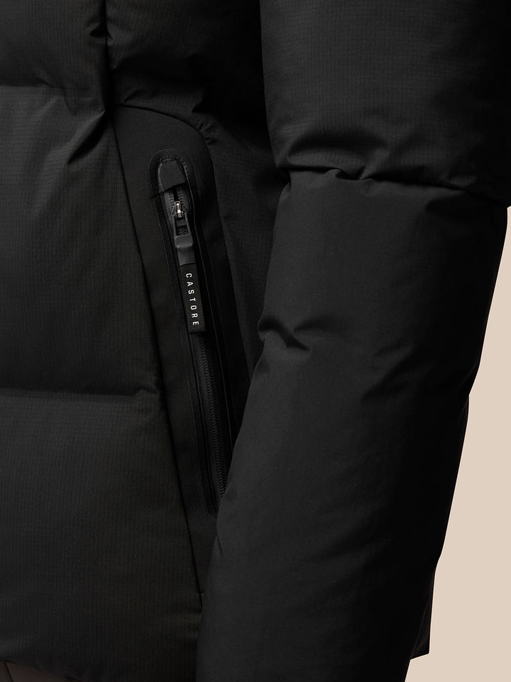 Close-up of vertical zipper on black puffer jacket with Castore branded zipper pull