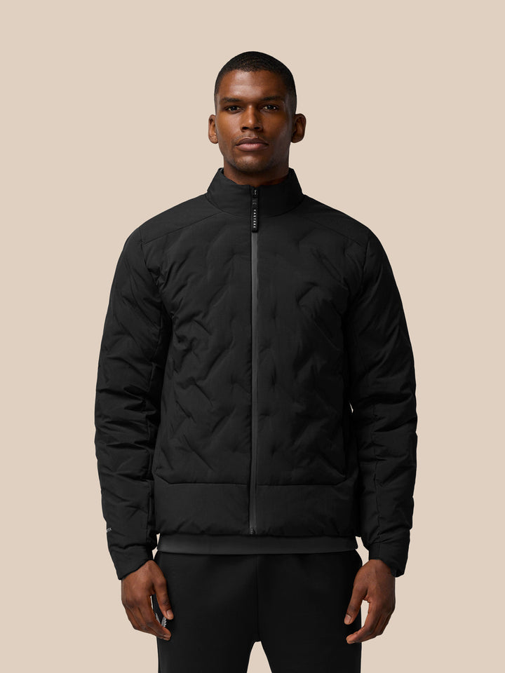 Front view of a man wearing a black padded jacket with stand collar and full front zip