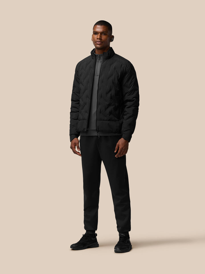 Man wearing black padded jacket with stand collar, full front zipper and zipped side pockets