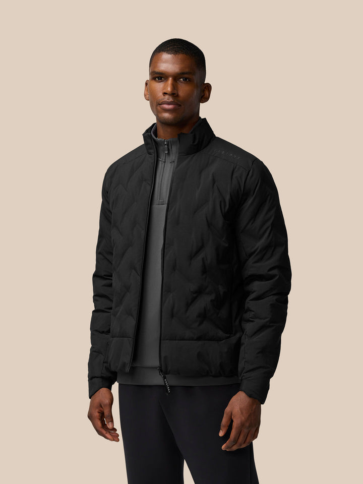Three-quarter view of a man in the black padded jacket with stand collar and center zip