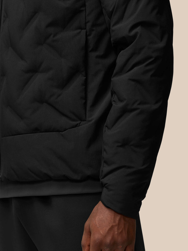 Close-up of black padded jacket sleeve with Protek branding near the cuff