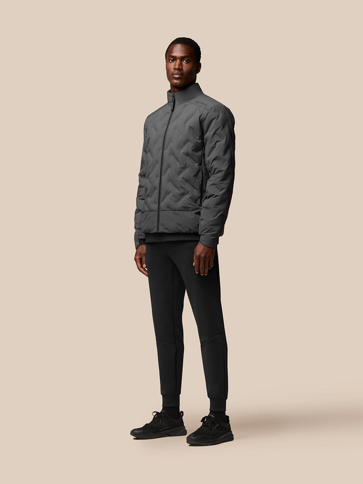 Male model wearing charcoal Quilts Lifestyle Jacket with stand collar and full zip.