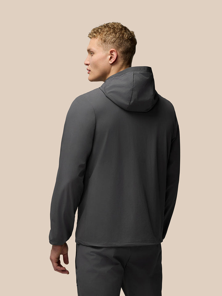 Back view of charcoal Lightweight Flex Jacket with hood worn by a male model