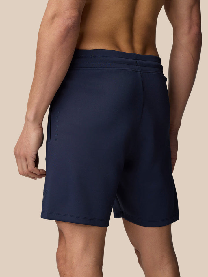 Close up of navy Flex Shorts waistband with drawcord and pocket seam on a model.