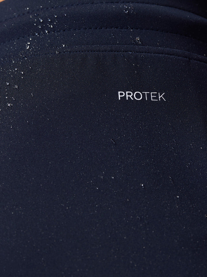 Close-up of navy fabric with water droplets and PROTEK branding on the Flex Shorts