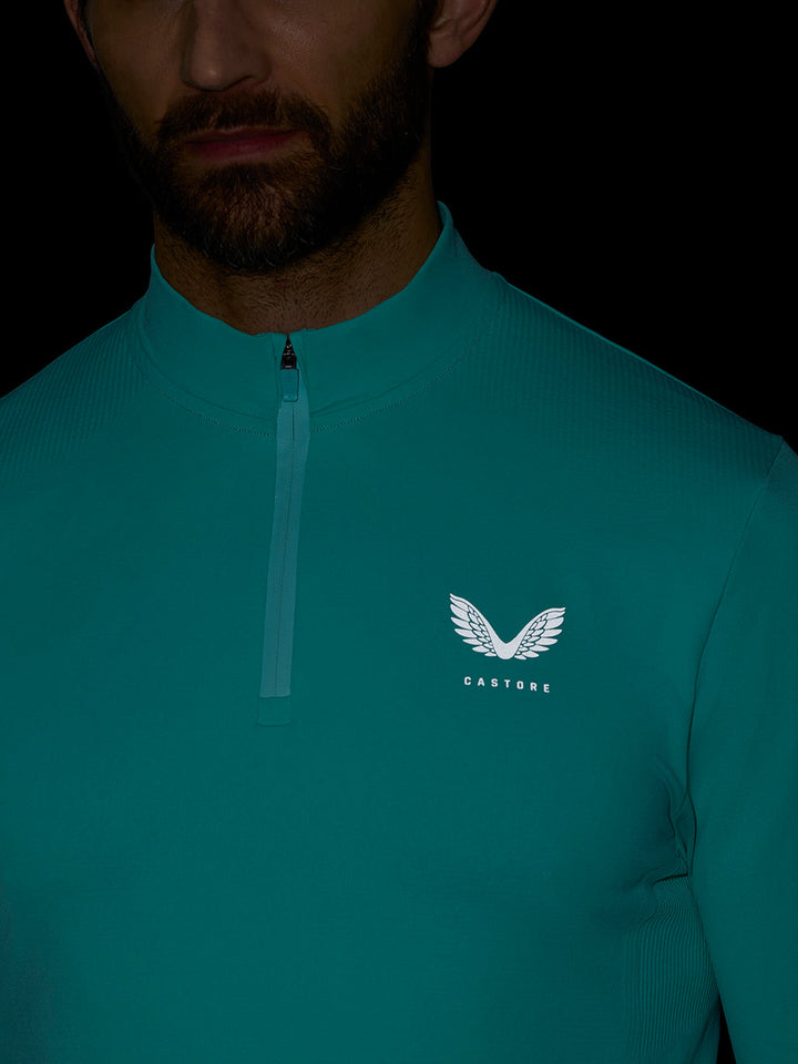 Chest close up of Zone Training top in light aqua with a front zipper and a logo on the left chest.