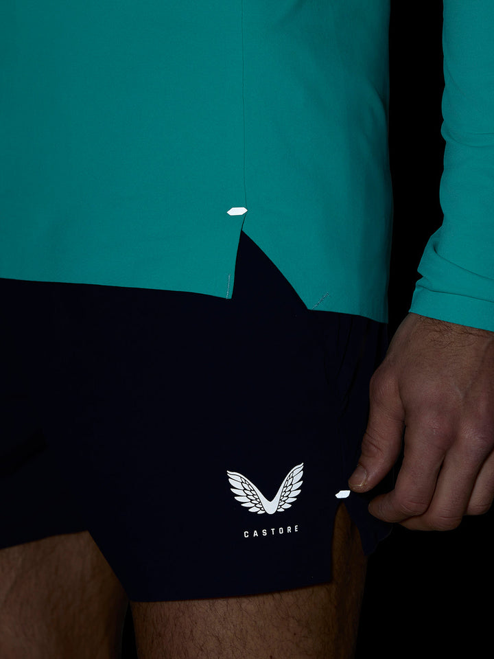 Teal Zone Training 1/4 Zip top close up highlighting side hem seam and small reflective detail.