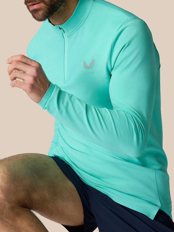 Front view of a man wearing Zone Training quarter zip top in light aqua with a high neck and logo on the chest.