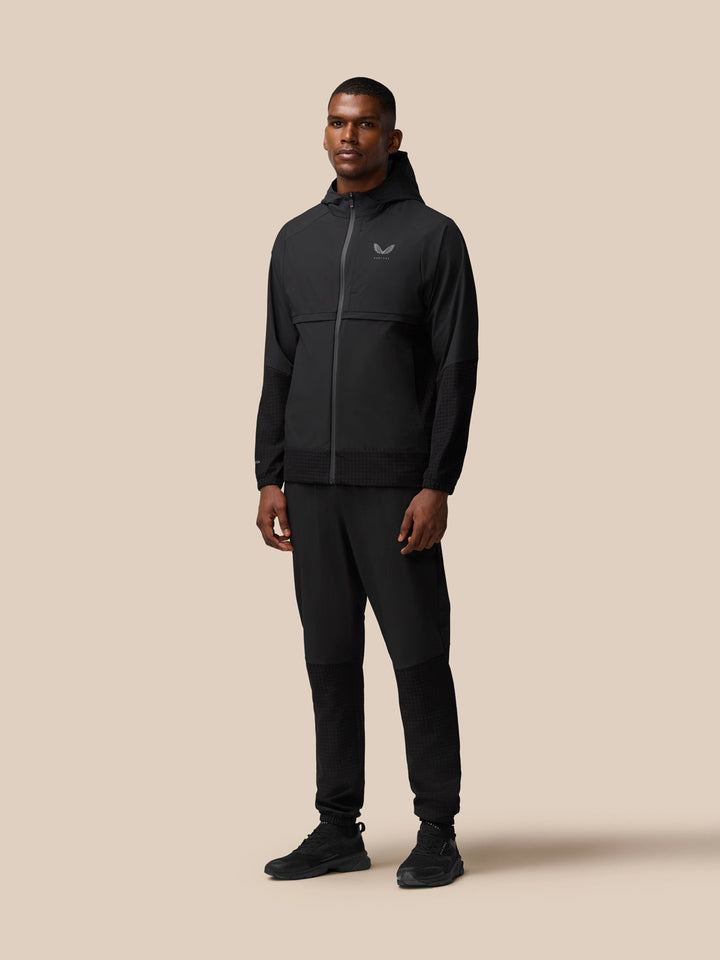 Full back view of a man wearing black Flex Winterised Woven Joggers and a jacket highlighting the joggers silhouette.