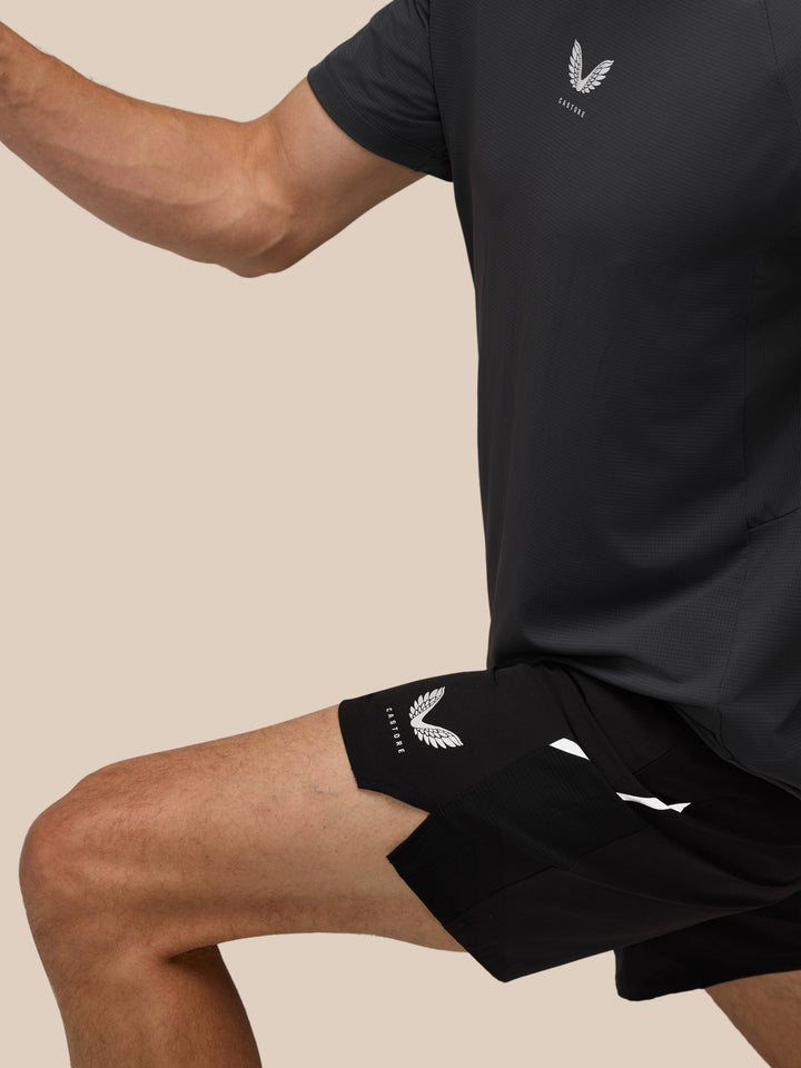 Close-up of a dark Apex training shirt on a model with the Castore emblem on the chest