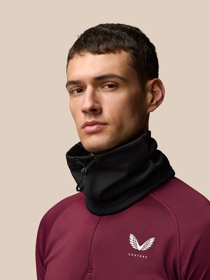 Male model wearing the black Castore Active Snood around the neck.