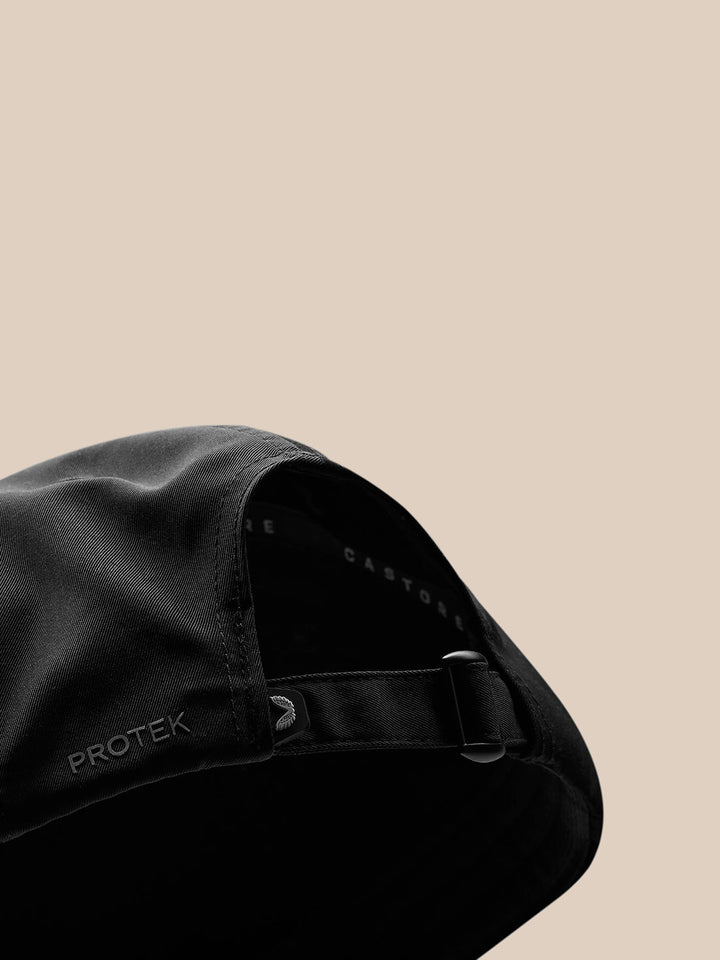 Back view of black cap with adjustable strap buckle and PROTEK branding