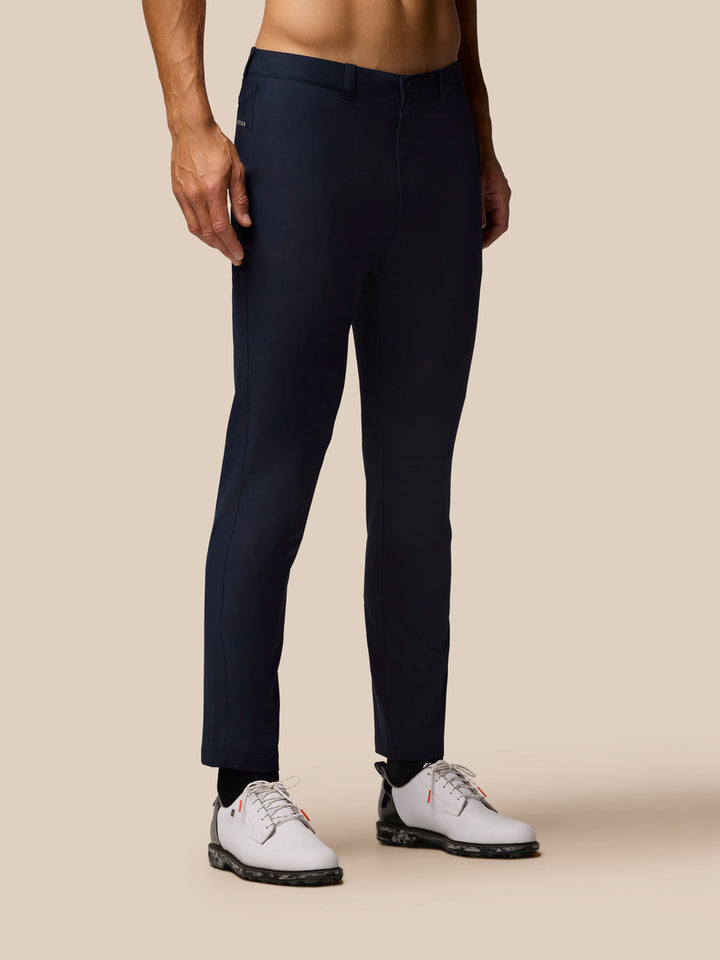 Midnight navy Golf Club Trousers on a model with open side pockets and branding on the front