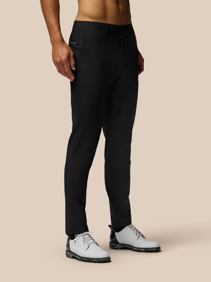 Front view of a man wearing black Golf Club Trousers 32-inch with white golf shoes.