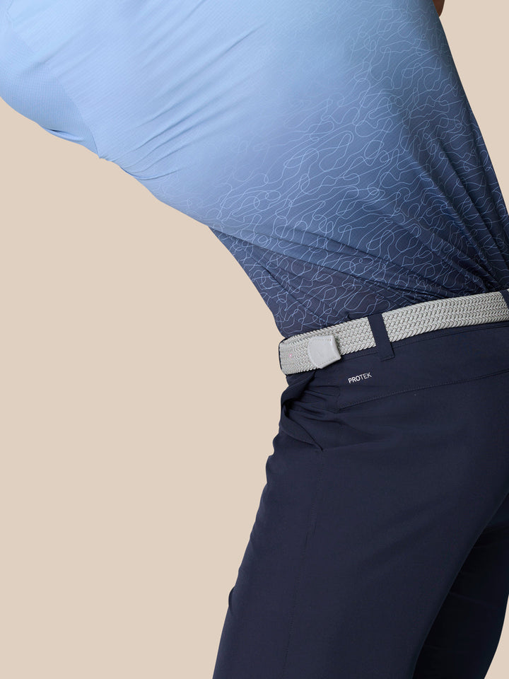 Side close-up of navy golf shorts showing ProTek branding near the back pocket and the textured belt.