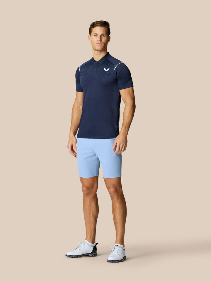 Male model in navy Castore polo and sky blue golf shorts from the Golf Club collection
