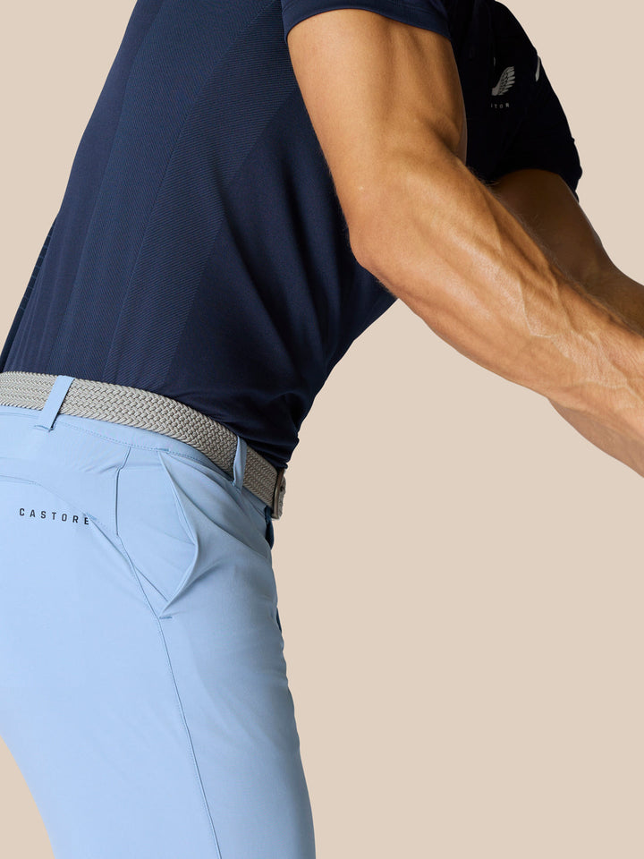 Back view of light blue golf shorts with braided belt and navy top, Castore branding on right thigh