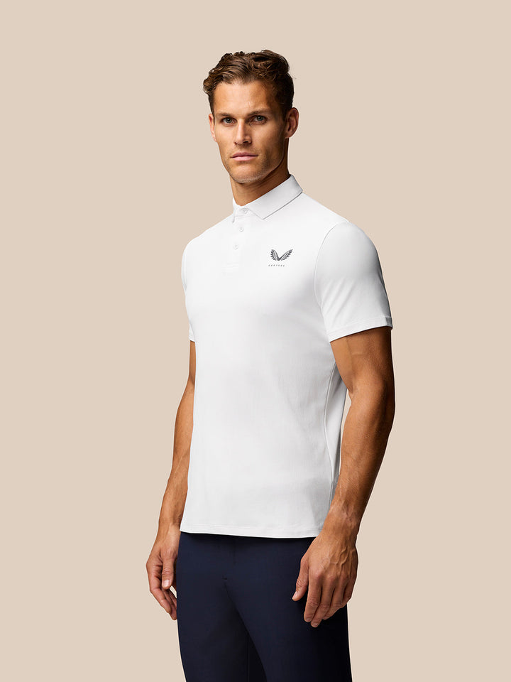 Man wearing white Golf Club Essential Polo with polo collar and short sleeves.