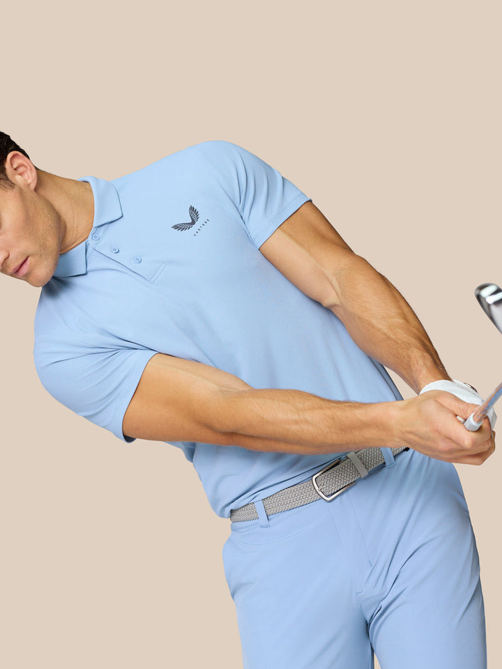Rear close-up of a man in sky blue Golf Club Essential Polo showcasing Castore branding along the upper back.