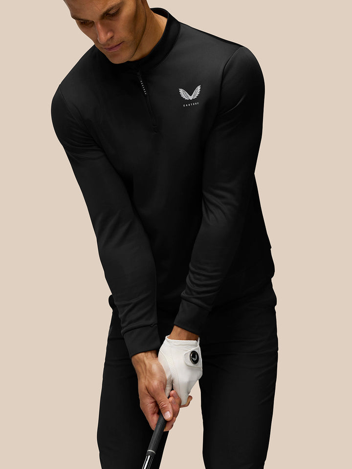Male model in black Golf Club Classic 1/4 Zip Top with front quarter zip and Castore branding on chest.
