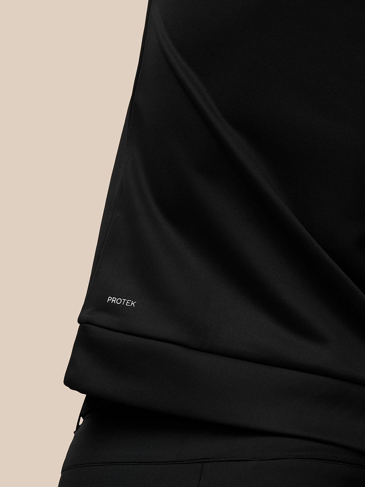 Close-up of black fabric showing Protek branding on the sleeve.