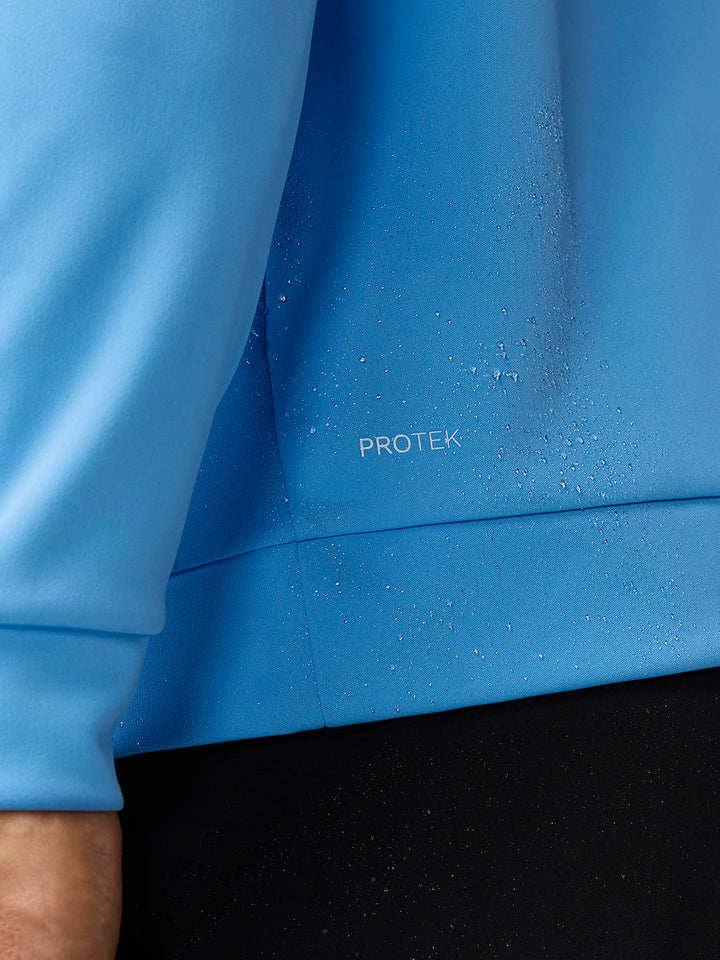 Close-up of blue PROTEK fabric with water droplets on the Golf Club Classic top