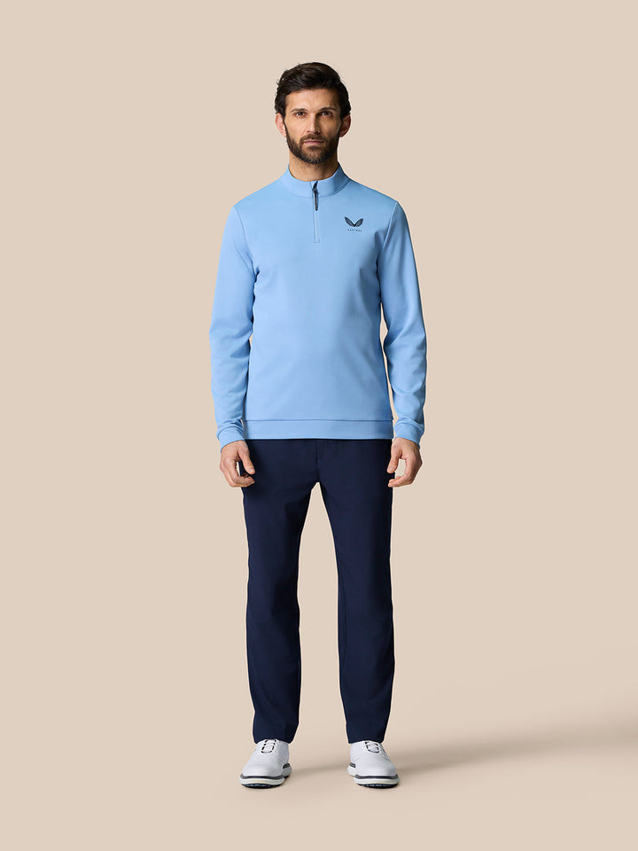 Male model wearing sky blue Golf Club Classic Quarter Zip Top with stand collar and front quarter zip; Castore logo on chest