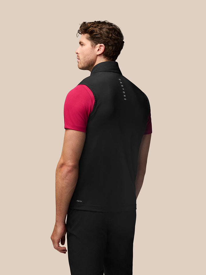 Back view of male model in black Golf Pinnacle Gilet with stand collar and subtle branding along the upper back