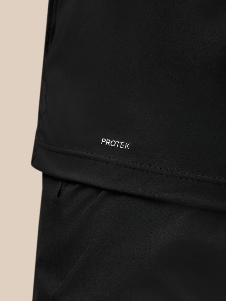 Close-up of lower back hem showing PROTEK branding on the black gilet