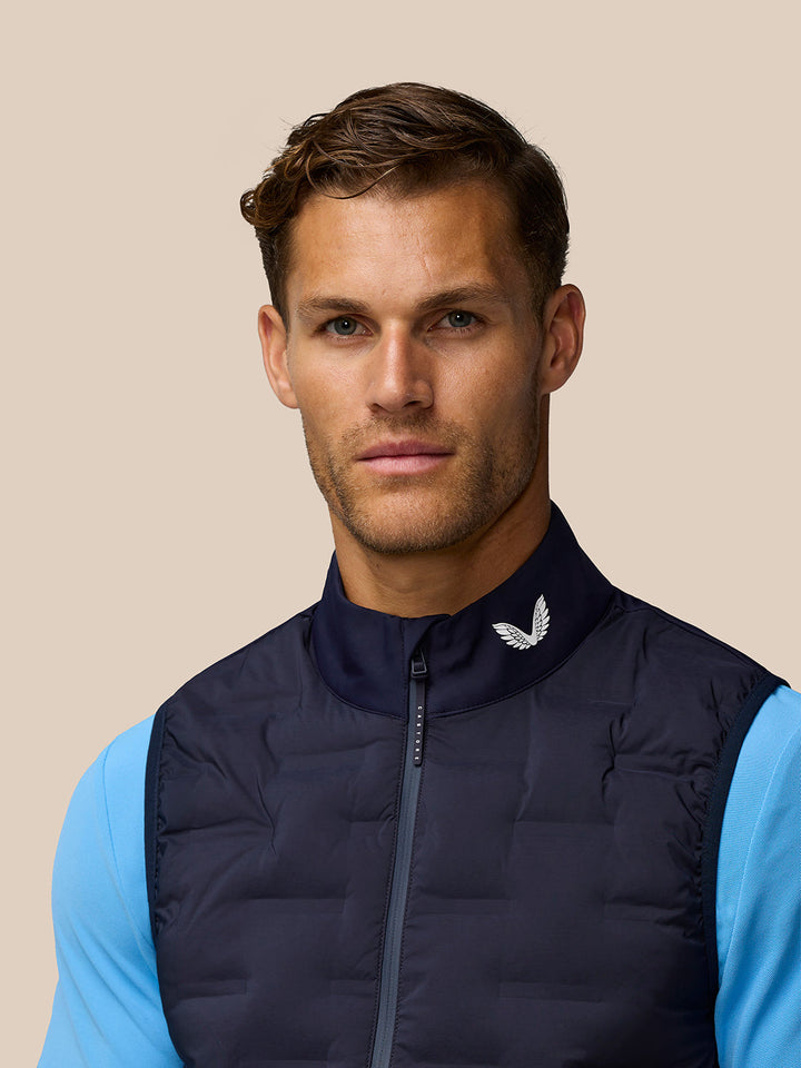 Male model wearing midnight navy Pinnacle golf gilet with stand collar and front zip