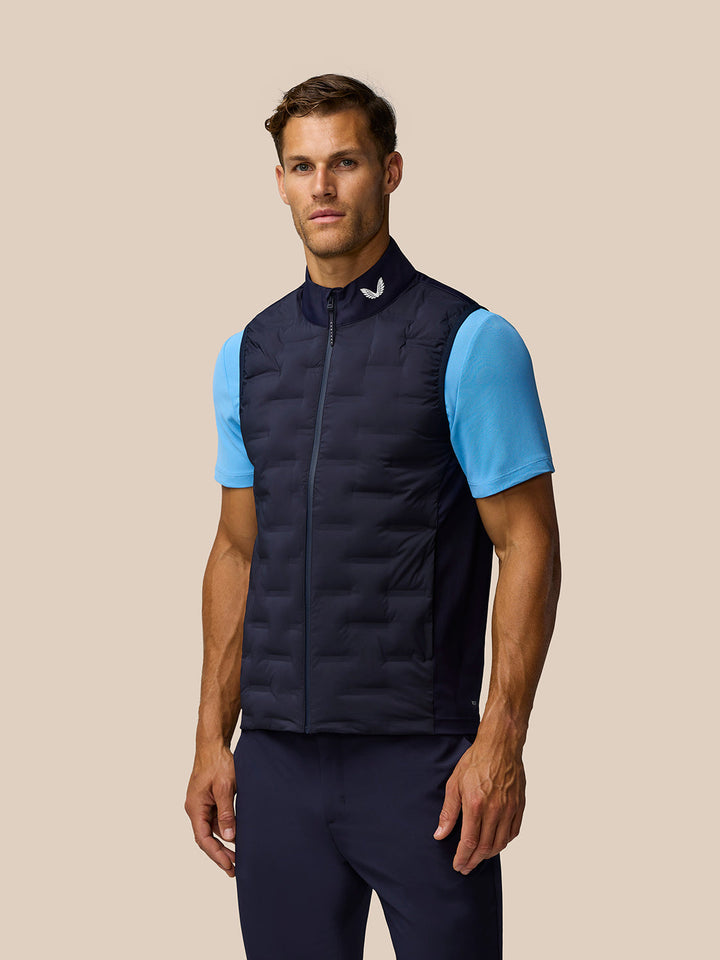 Male model wearing navy Pinnacle Gilet with front zip and light blue base layer.