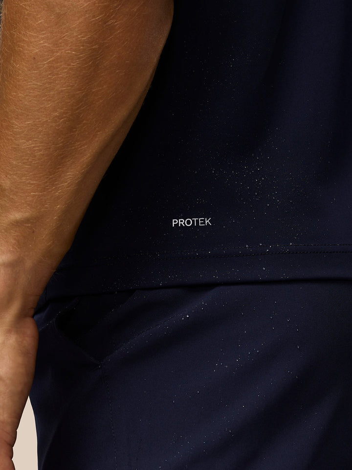 Close up of PROTEK fabric on navy Pinnacle Gilet with arm in frame.