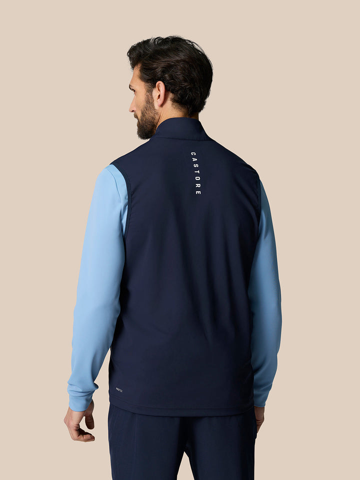 Back view of navy Pinnacle Gilet showing vertical Castore branding along the upper back