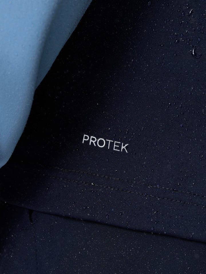 Close-up of navy Protek fabric with white PROTEK text and water droplets.