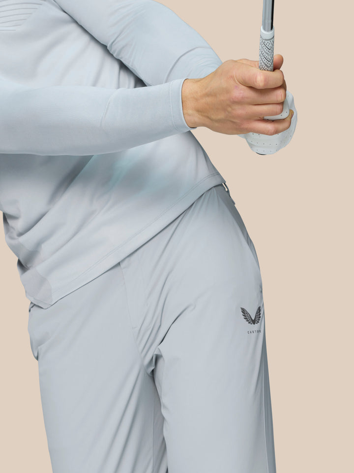 Male model in pale blue Castore golf top with zip collar and chevron texture